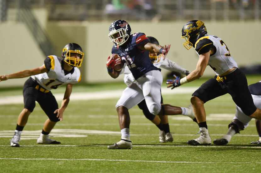 Ryan running back Tyreke Davis (21) runs through the defense during their game against...