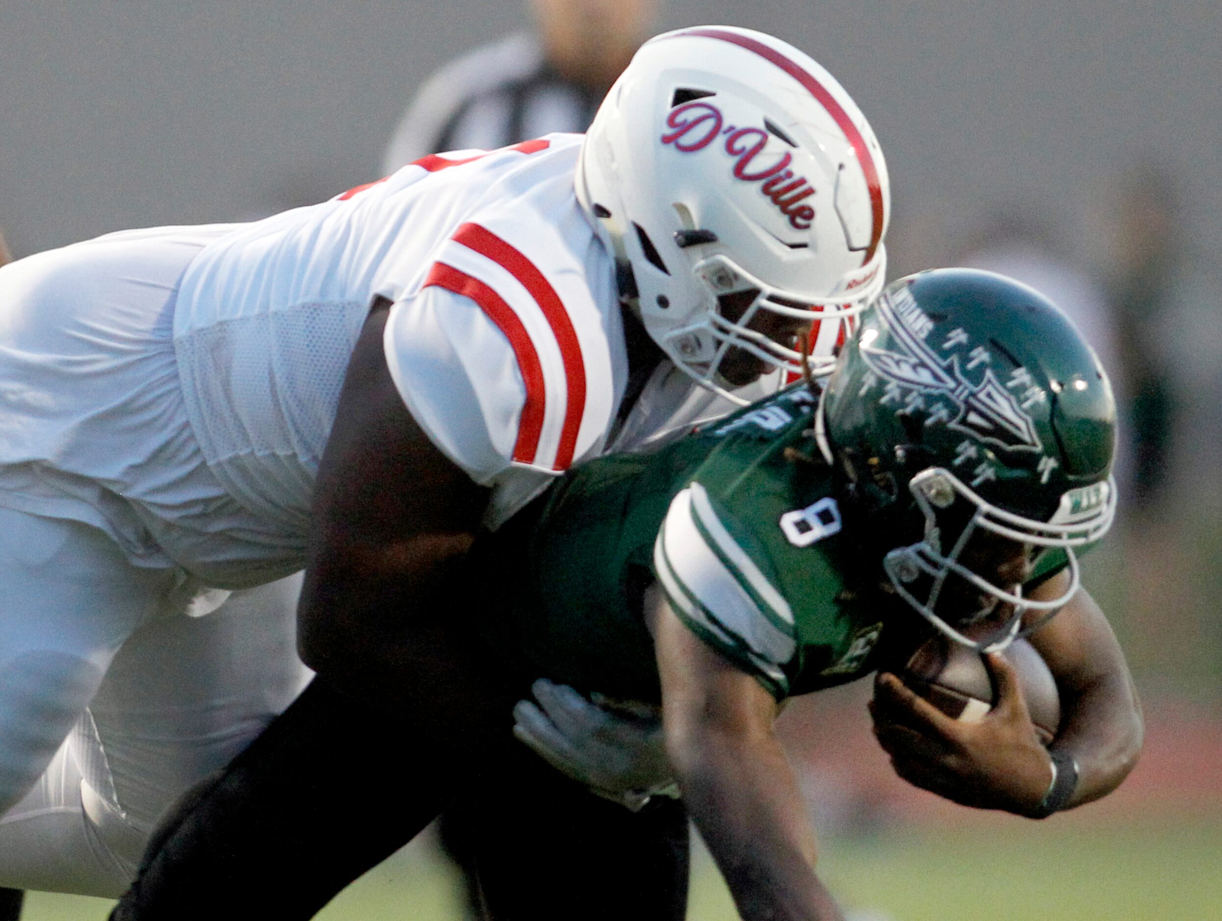 Waxahachie quarterback Ramon McKinney, Jr. (8) is dropped for a loss by Duncanville...