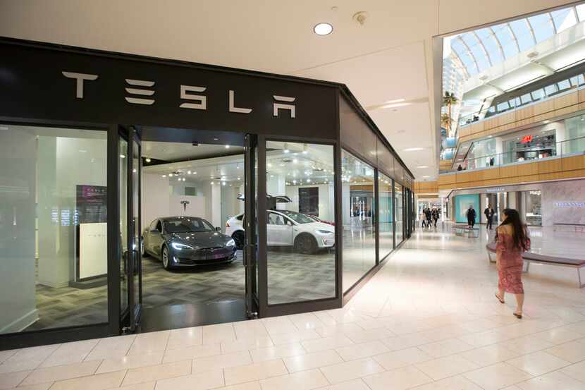 A woman walks past the Tesla showroom inside Galleria Dallas. The showroom is on the first...