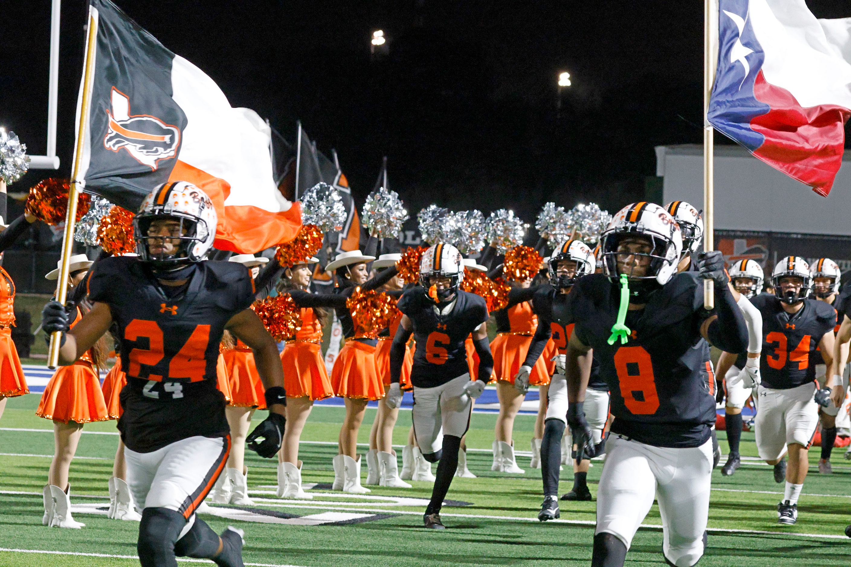 Haltom players run out to the field before a high school football game against Sam Houston...