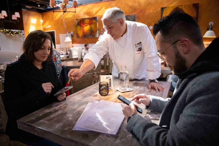 La Duni co-owner Taco Borga (center) walks Chelsea Guice (left) and Rafael Torres through...