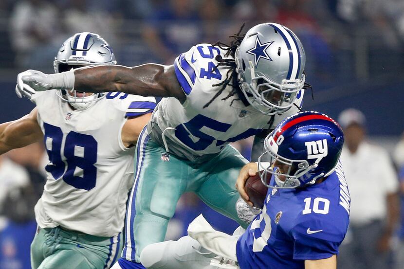 New York Giants quarterback Eli Manning (10) is hit hard and tackled by Dallas Cowboys...