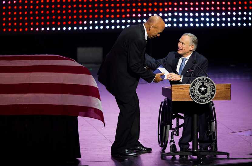 Gov. Greg Abbott makes a presentation to Volma Overton, Jr. during a memorial service for...