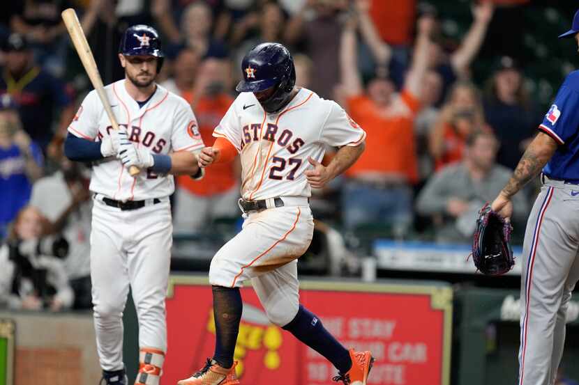 Houston Astros' Jose Altuve (27) scores the winning run on a wild pitch by Texas Rangers...