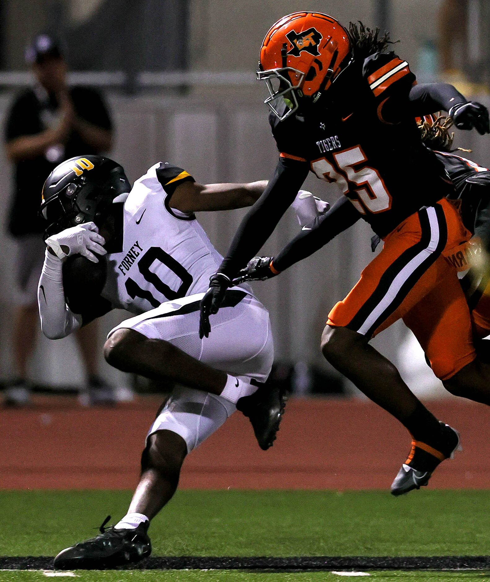 Forney wide receiver Kofi Eduful (10) gets pushed out of bounds by Lancaster defensive back...