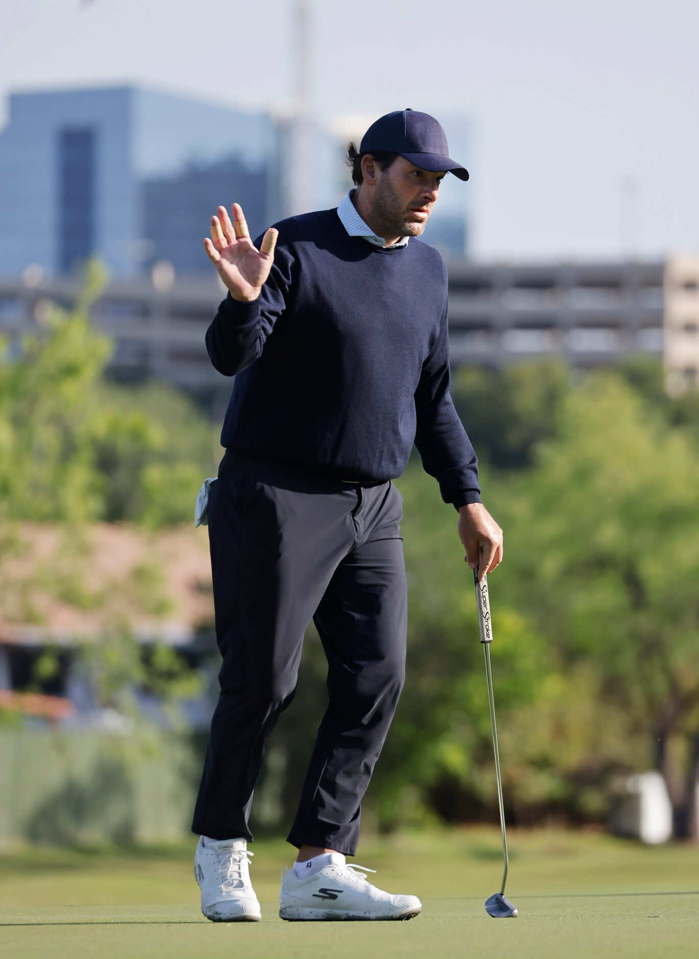 Former Dallas Cowboys quarterback Tony Romo waves after sinking a putt on No. 11 during the...