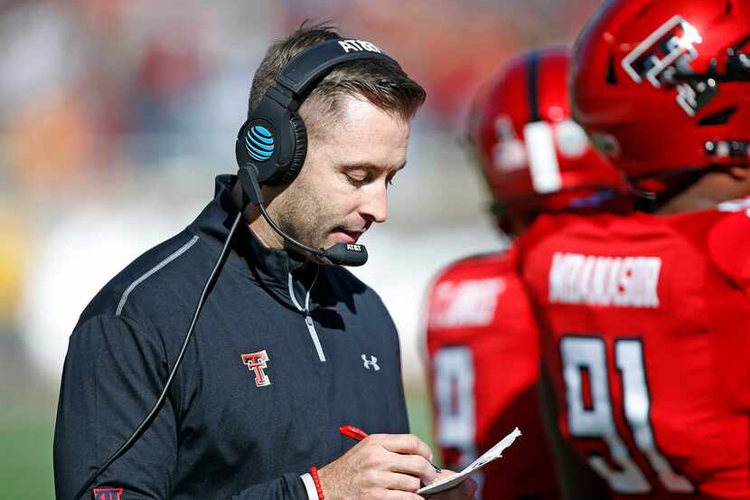 Texas Tech coach Kliff Kingsbury looks down at his notes during the second half of the NCAA...