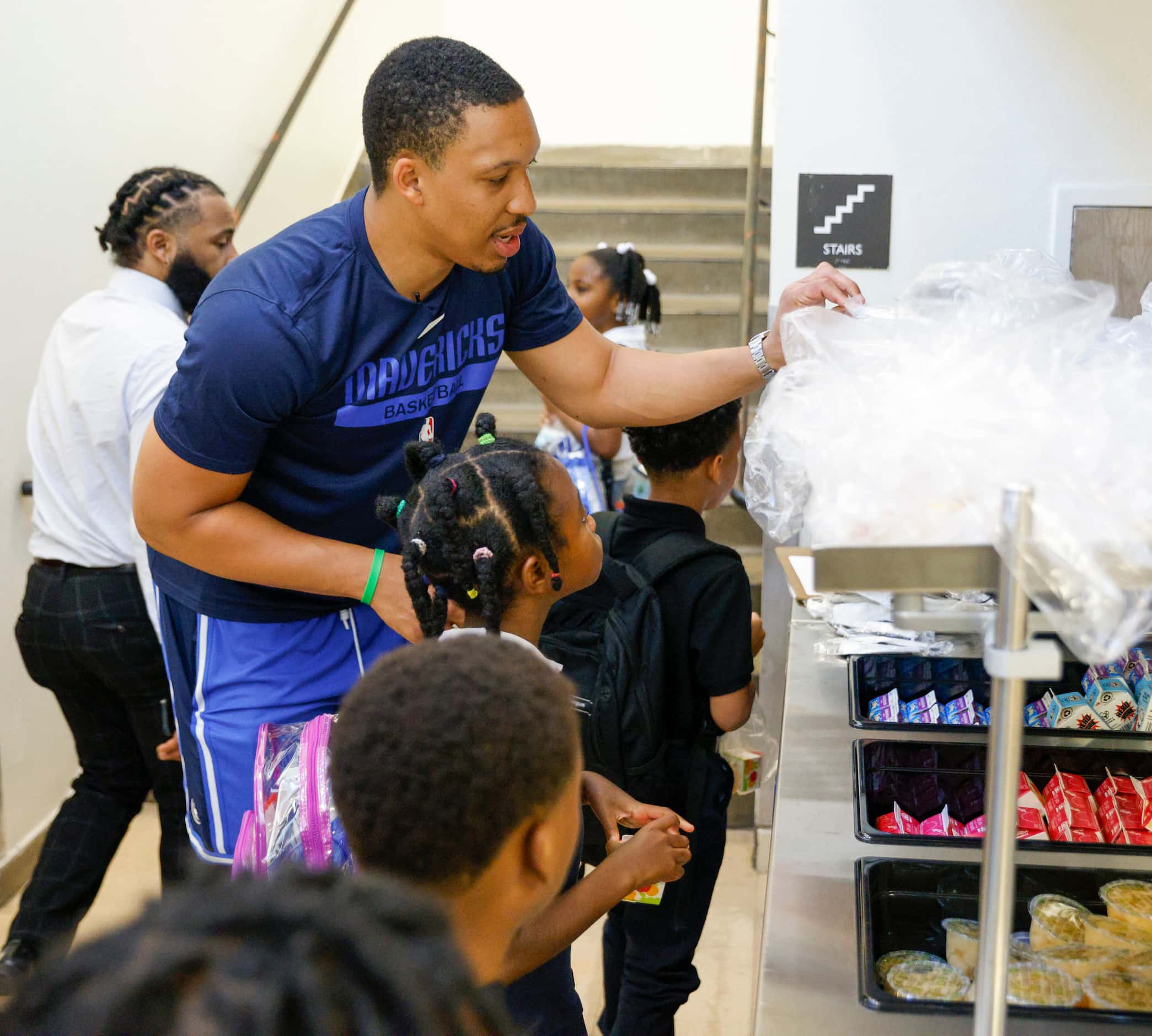 Dallas Mavericks forward Grant Williams helps pass out breakfast to students during the Mavs...
