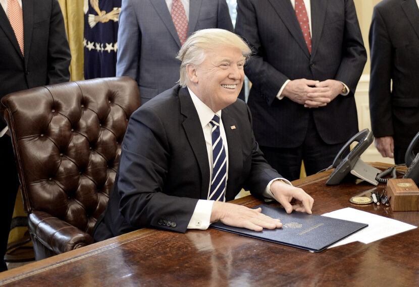 President Donald Trump signs House Joint Resolution 41 in the Oval Office of the White House...
