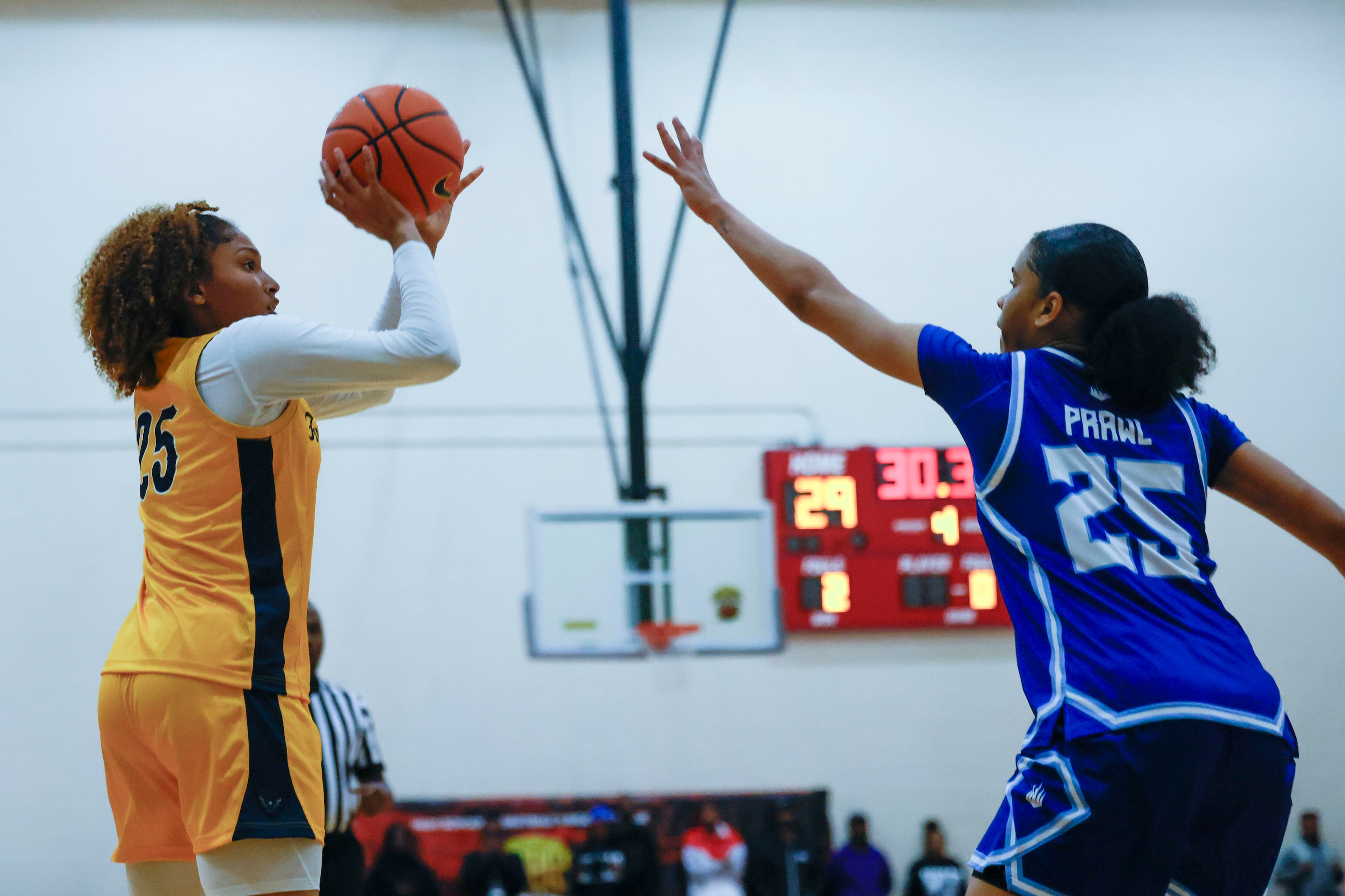 Oak Cliff Faith Family Academy’s Amayah Garcia (left) shoots a three pointer past IMG...