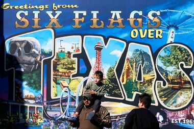 Patrons walk past a mural at Six Flags Over Texas on Saturday, March 9, 2024, in Arlington.