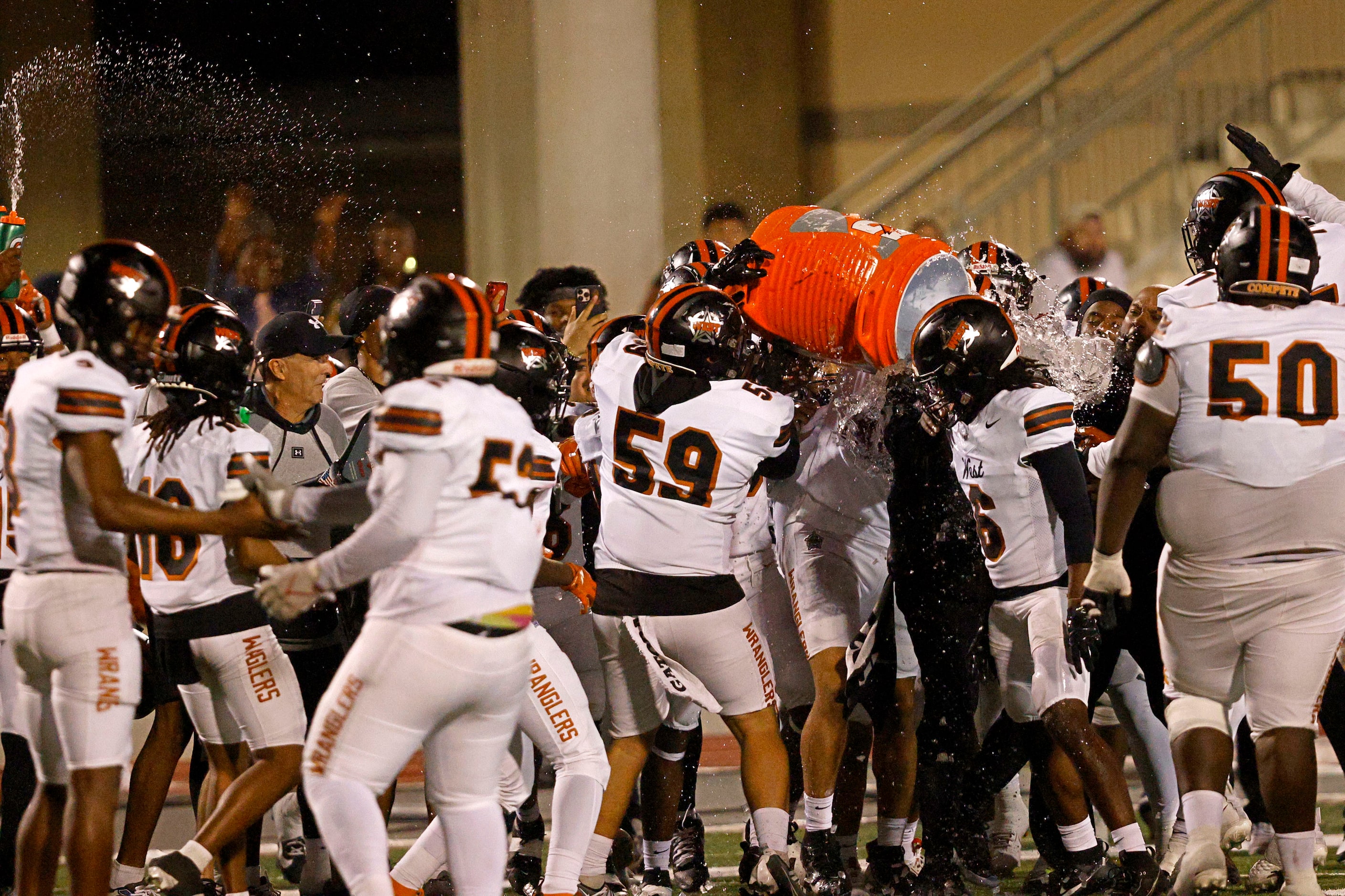 West Mesquite players celebrate their 20-13 victory against Newman Smith after a high school...