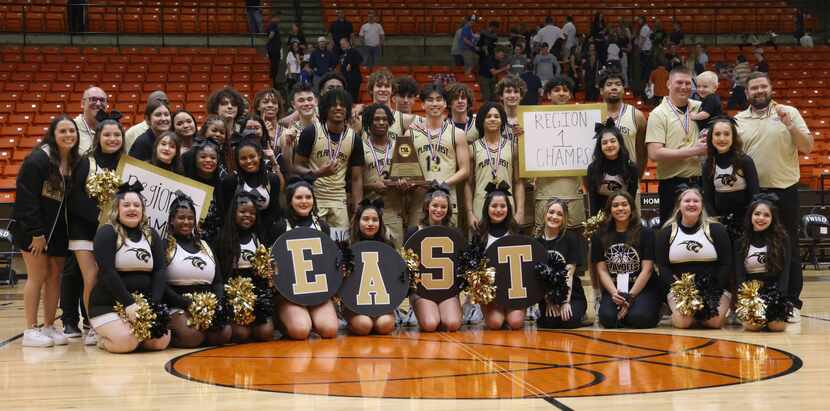 Plano East players, coaches and cheerleaders pose for a photo with medals and  the Region 1...