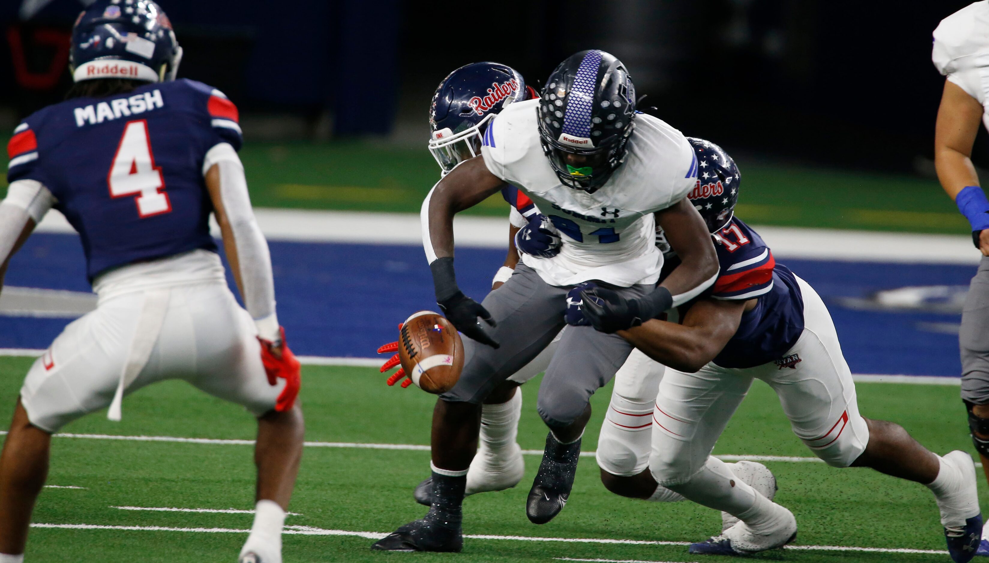 Mansfield Summit’s Desmond Walton (84) fumbles the football, after being hit by Ryan’s...