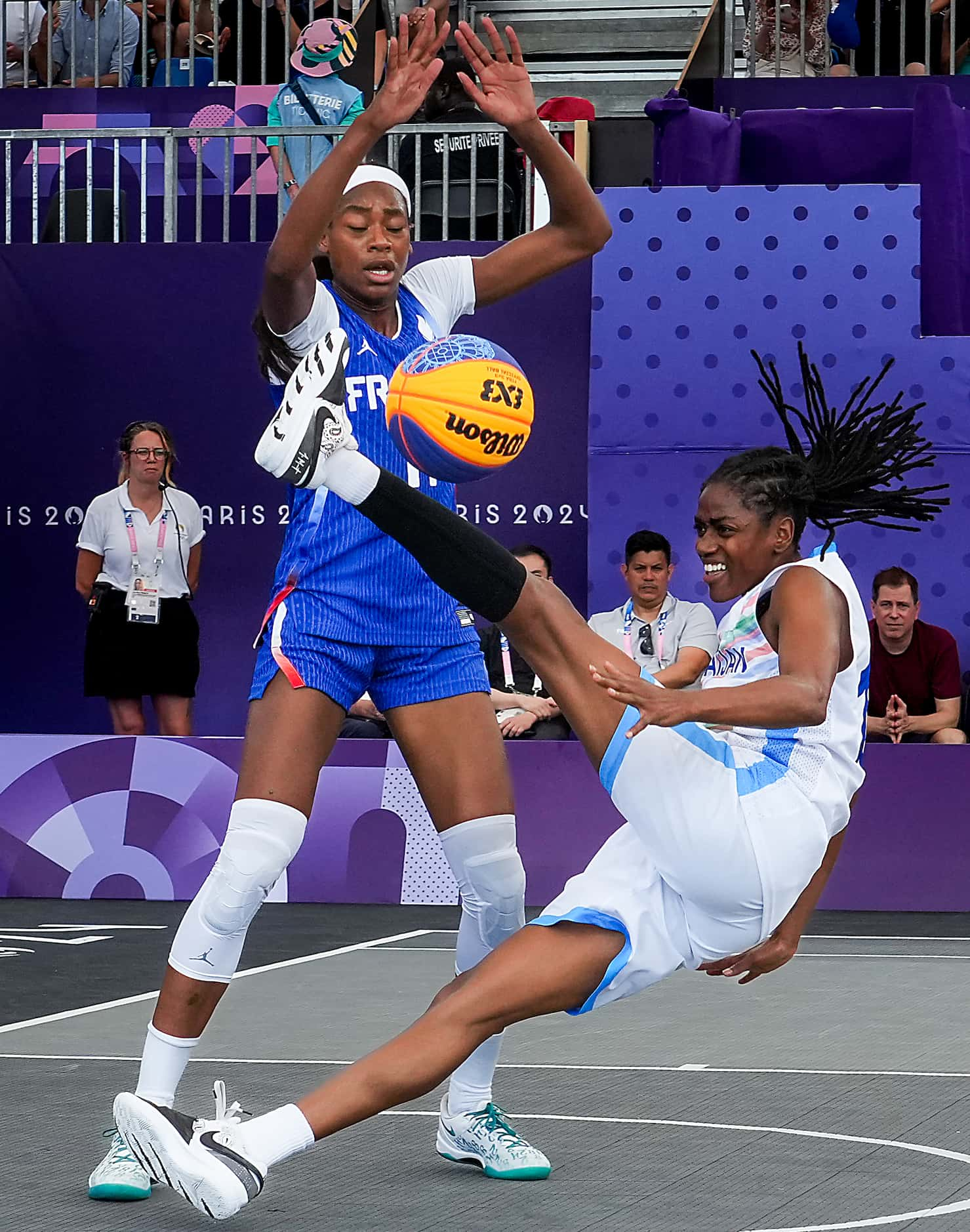 Tiffany Hayes of Azerbaijan (right) tumbles to the court as Myriam Djekoundade of France...