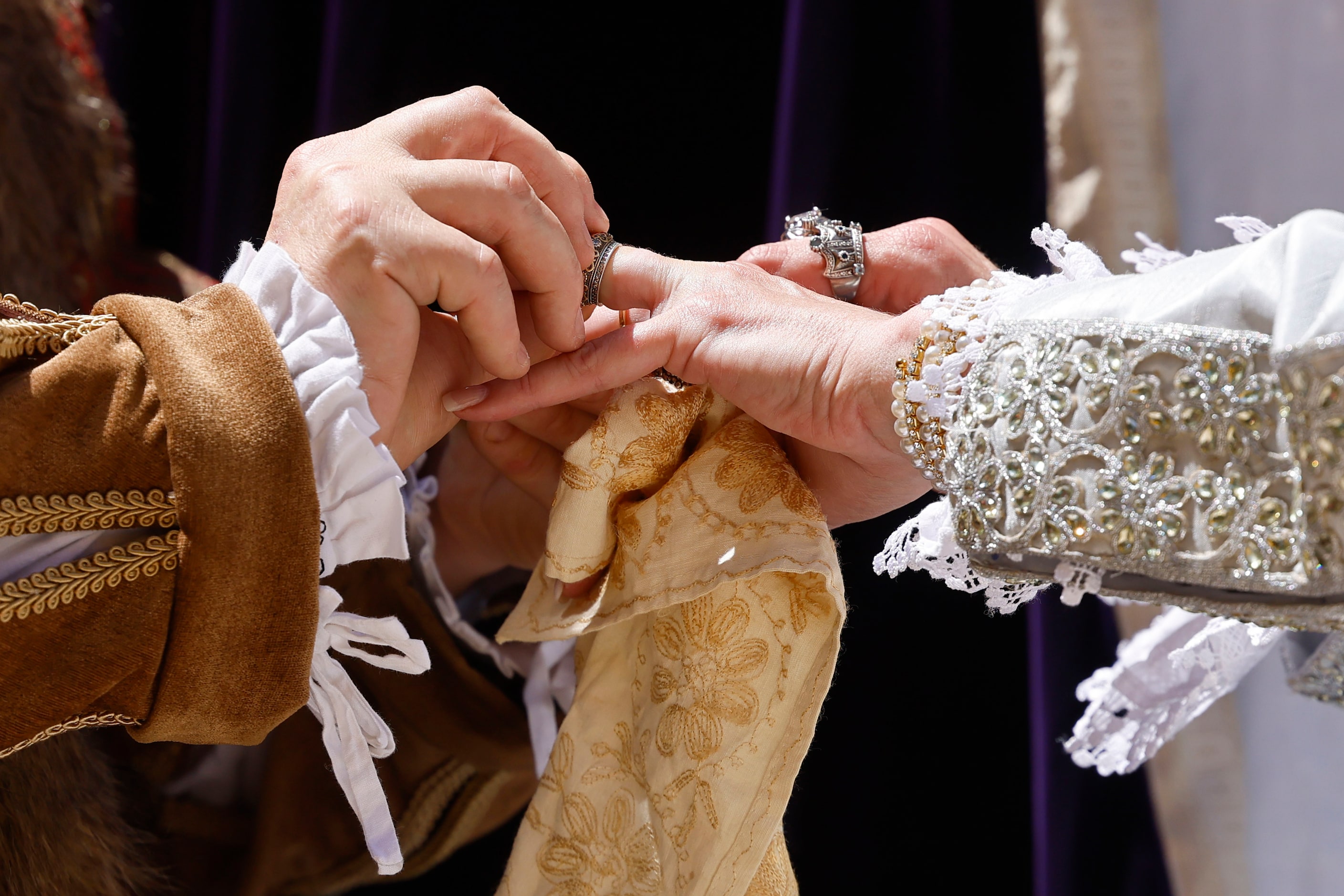 Mick Moreau (left), playing King Henry VIII, puts the ring on Janna Zepp, playing Queen...