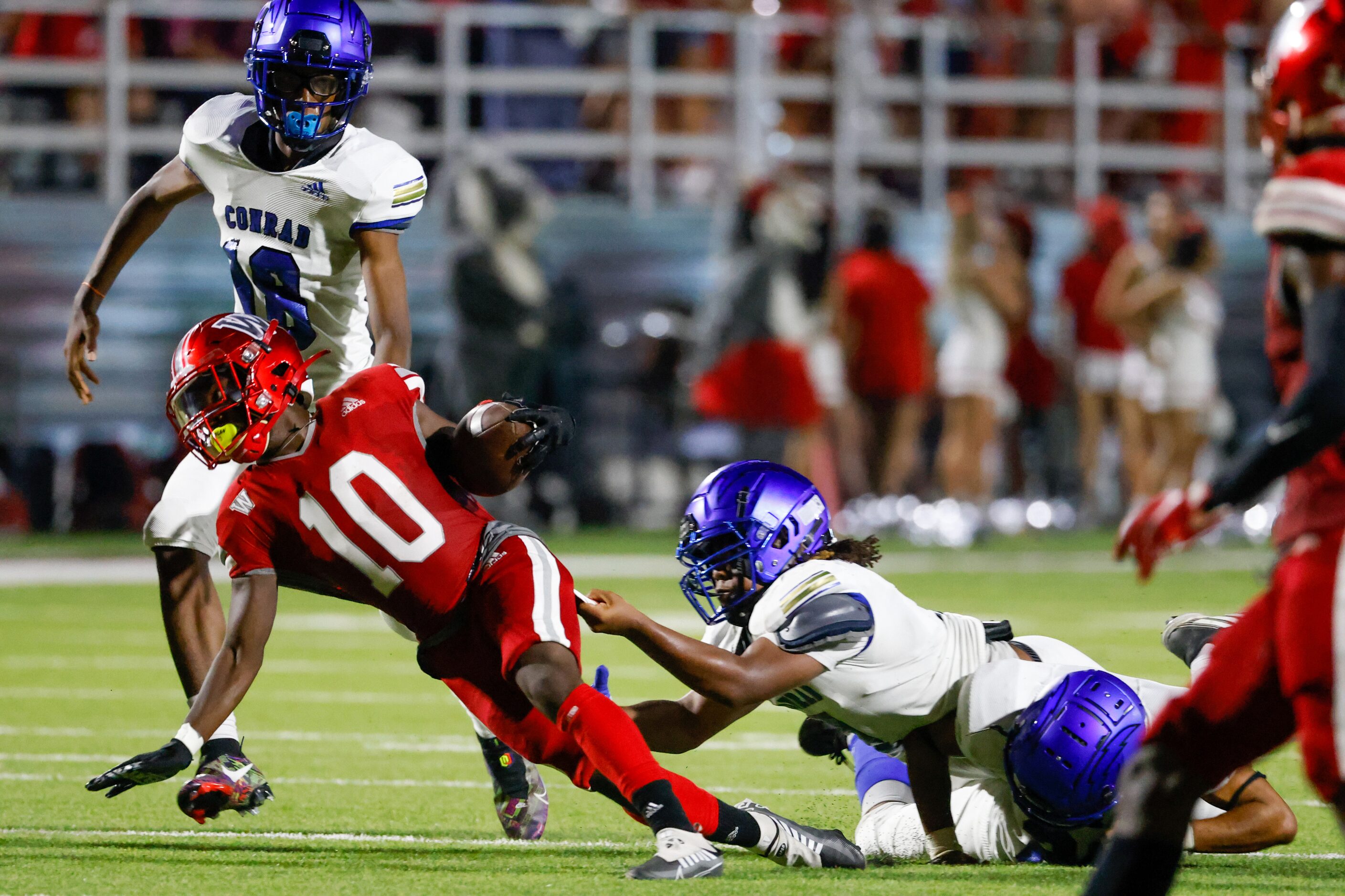 Woodrow Wilson wide receiver Jamel Tony-Black (10) is pulled on by Conrad defense during the...