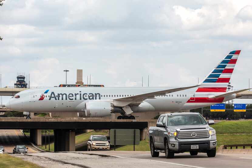 An American Airlines plane coasts the runway at DFW International Airport.