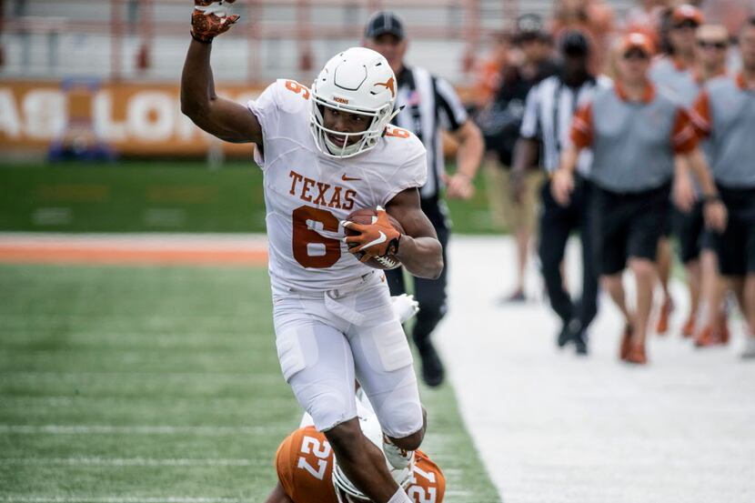 Texas' (6) Devin Duvernay tries to stay in bounds after beating (27) Donovan Duvernay on the...