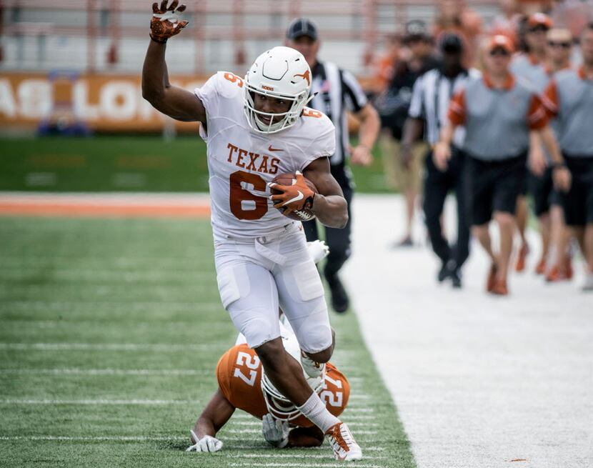 Texas' (6) Devin Duvernay tries to stay in bounds after beating (27) Donovan Duvernay on the...