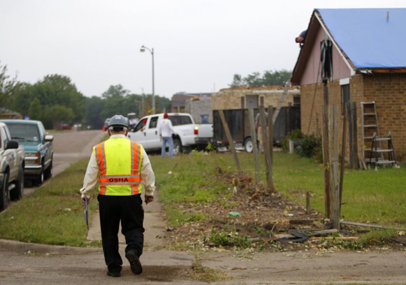 OSHA’s Elias Vela walks the Lancaster neighborhood ravaged April 3 by tornadoes. “We don’t...