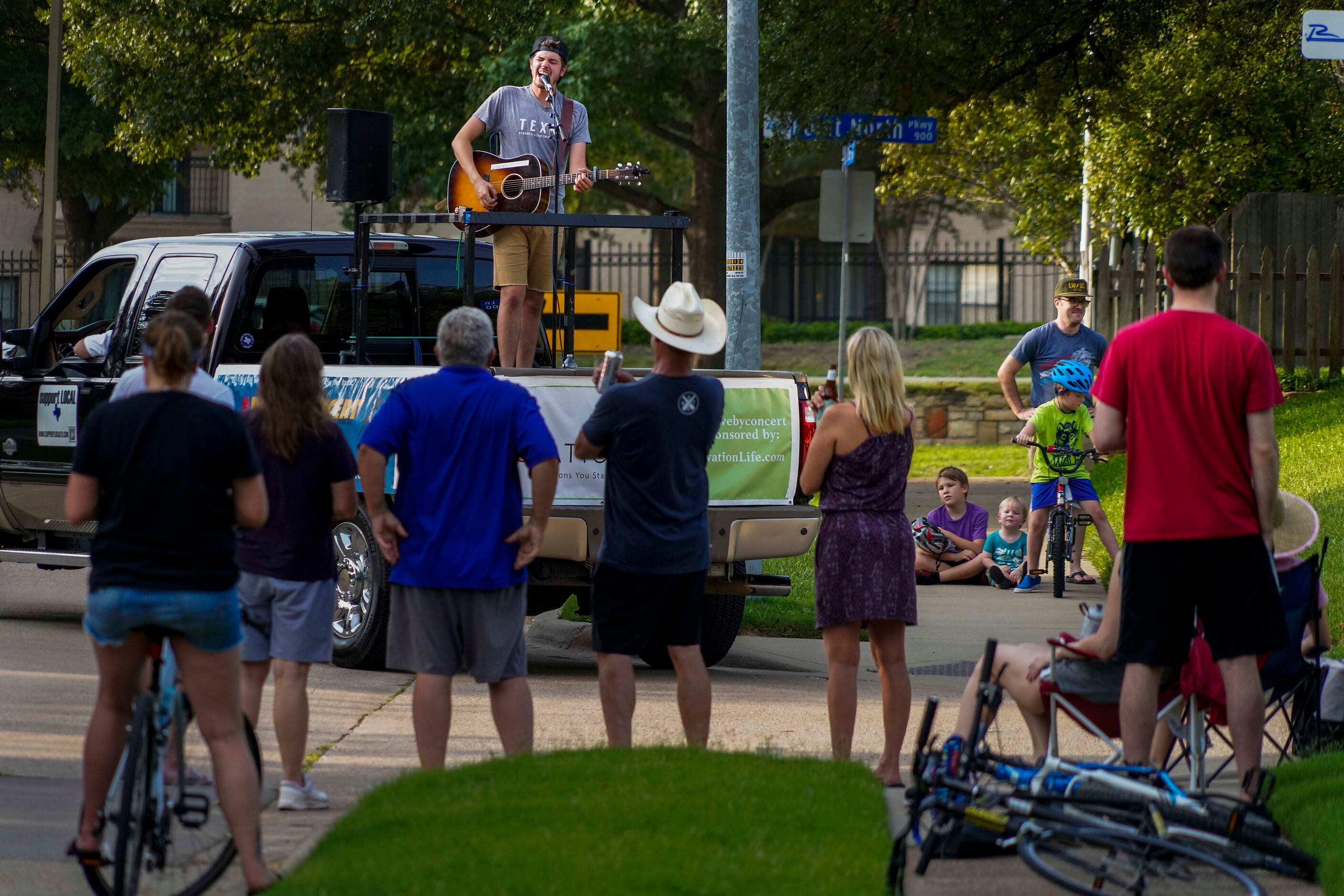 Cameron Havens sings from the back of a pickup truck during a 'Drive By Concert' through the...