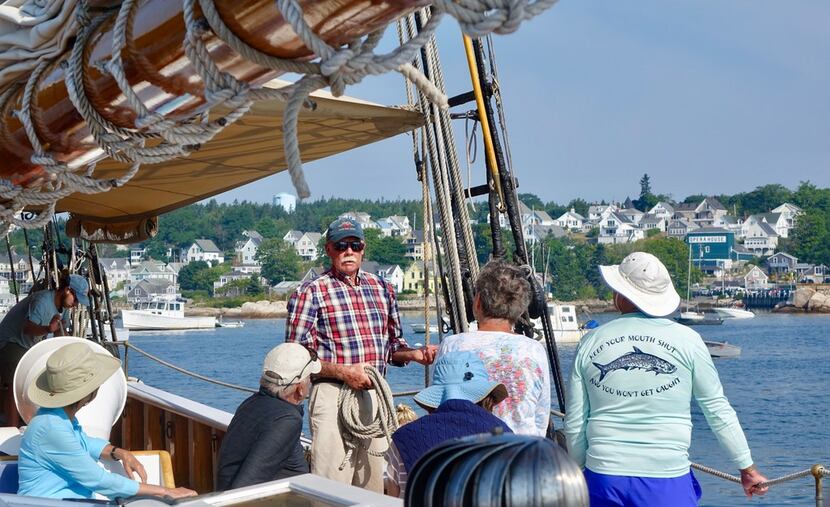 Capt. John Foss (center) explains to passengers how they will climb over the side and down a...