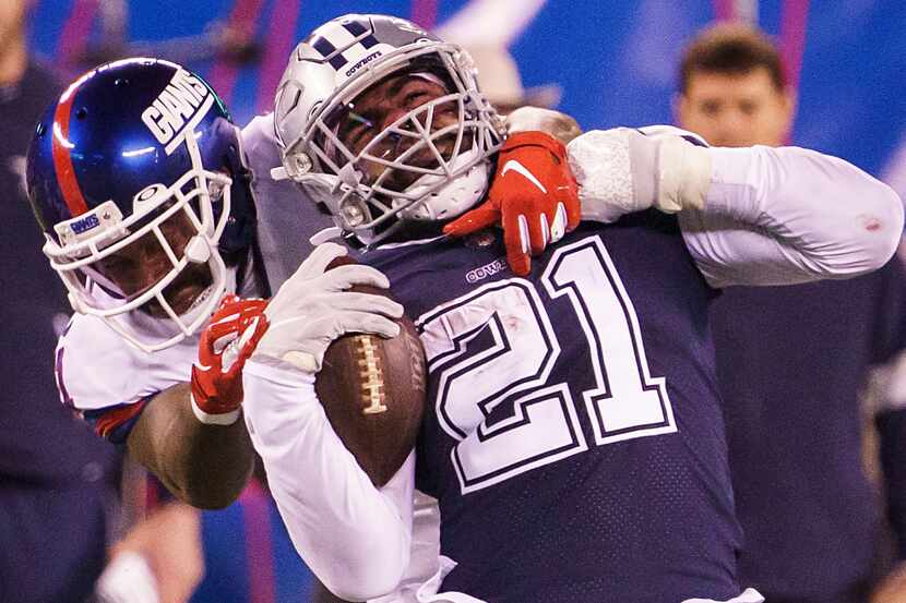 El corredor de los Dallas Cowboys, Ezekiel Elliott (21), es tacleado por el defensivo de los...