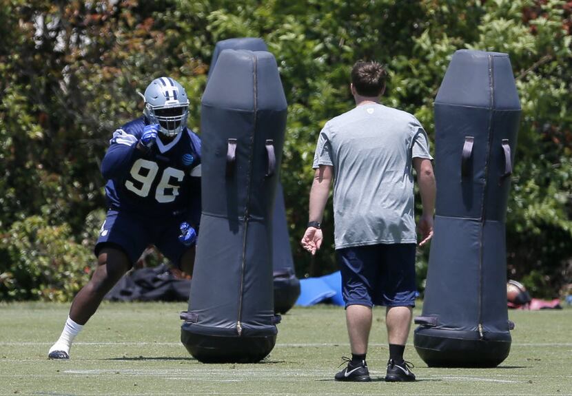 Dallas Cowboys defensive tackle Maliek Collins (96) works out with the tackle bags as a...