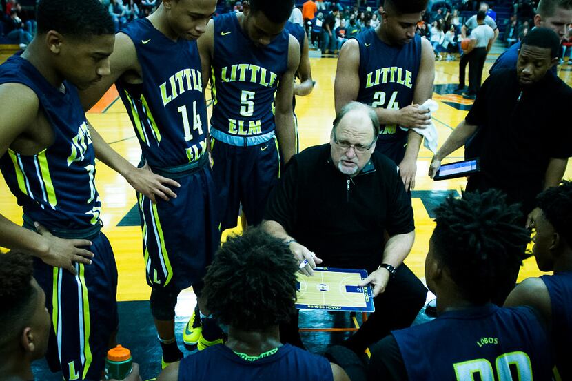 Little Elm boys basketball coach Rusty Segler works with his team during a timeout in a game...