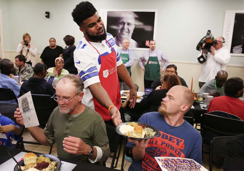 Dallas Cowboys running back Ezekiel Elliott (21) serves an early Thanksgiving Day meal to...