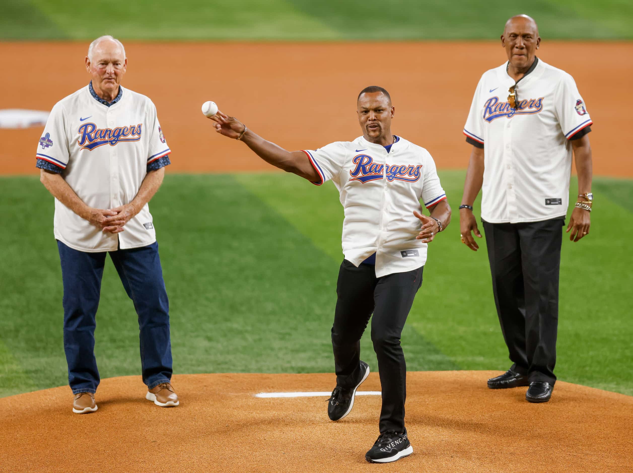 Former Texas Rangers third baseman Adrian Beltre throws the ceremonial first pitch alongside...