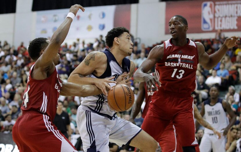 Miami Heat's Matt Williams, left, and Bam Adebayo, right, battle for the ball with Dallas...