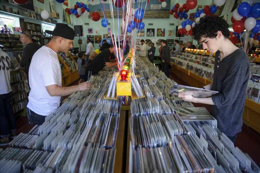 Philip Zamora (left) searches for albums along with other customers at Good Records as it...