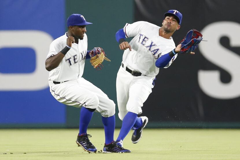 Texas Rangers center fielder Ian Desmond, right, catches a fly-out by the Oakland Athletics'...