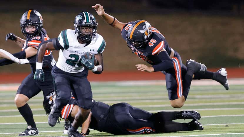 Prosper's Bryce Robinson (26) carries the ball against Rockwall's Justin Riekers (26), left,...