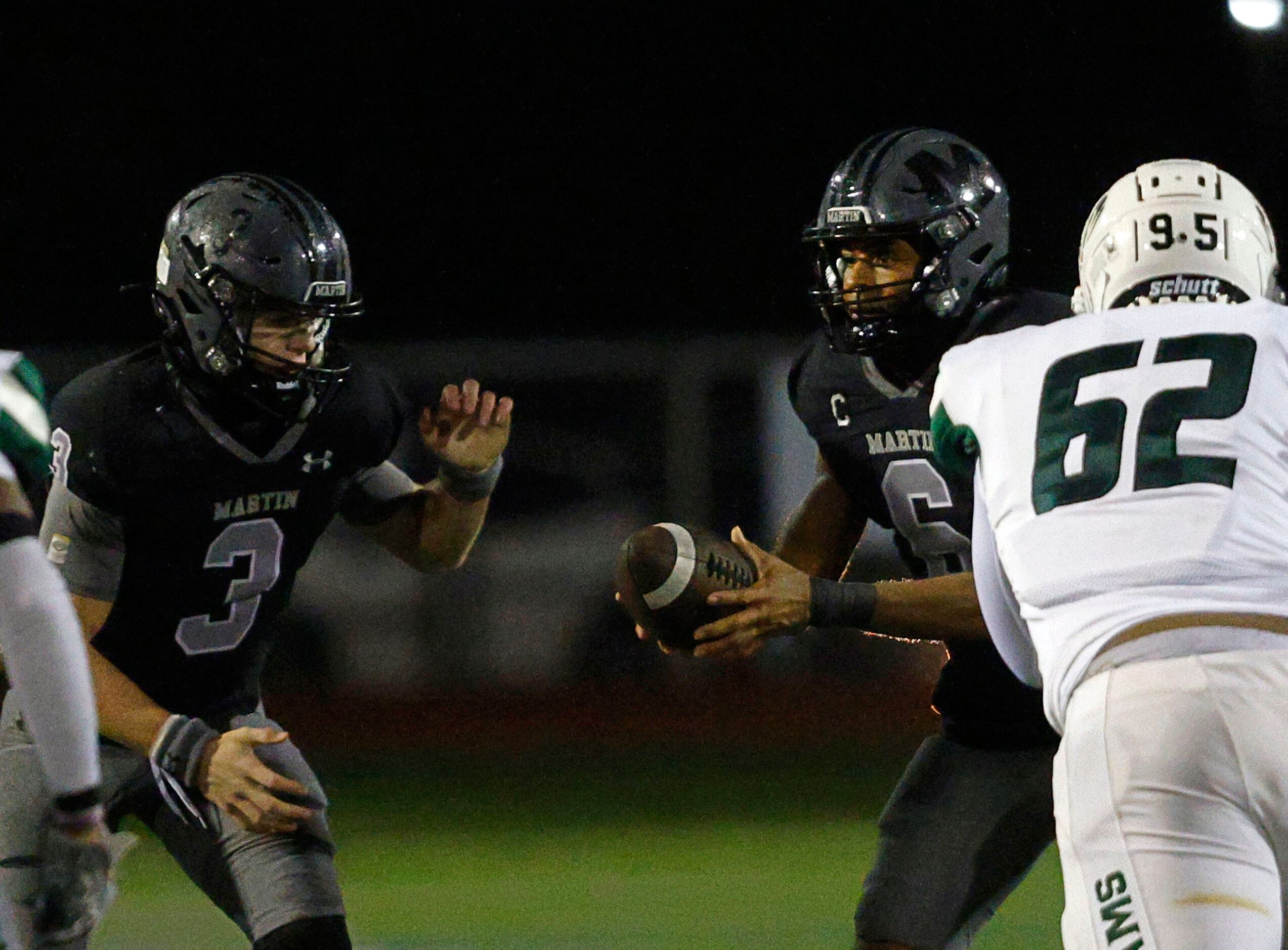 Martin's quarterback Tristan Bittle (6) hands off to Martin's Brooks Brigand (3) under...