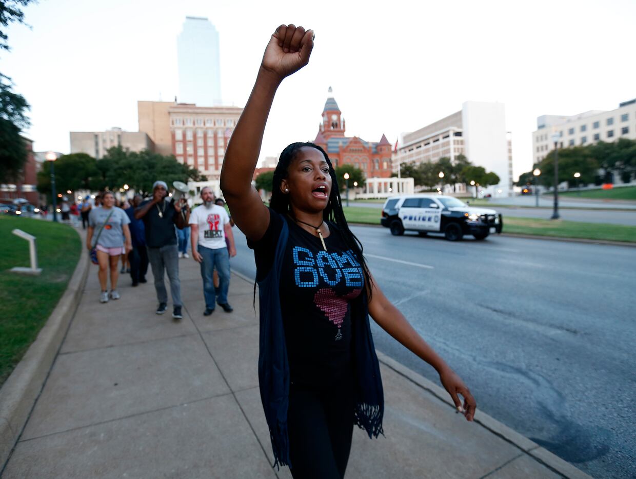 Tamara Neal raises her hand while protesters march on Commerce Street in Dallas, Wednesday,...