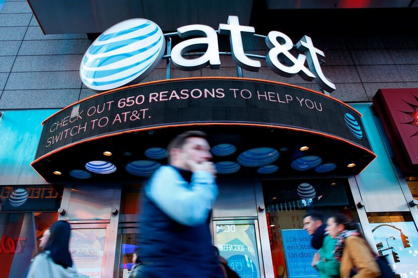 People walk past an AT&T store in New York in 2016