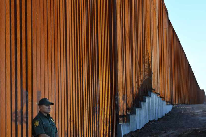 A Border Patrol officer keeps watch at the border wall in the El Centro Sector at the...