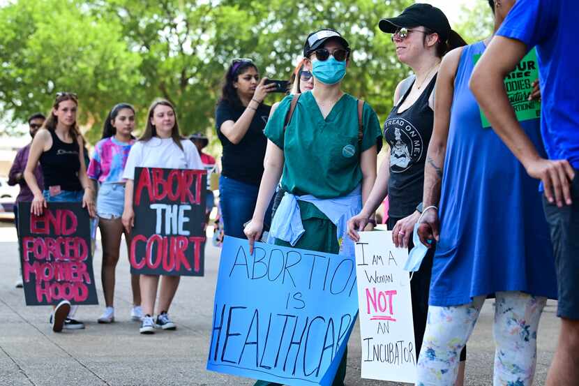 Emilie Nguyen, 28, center, and Heather Hall, 42, right, meet for the first time while...