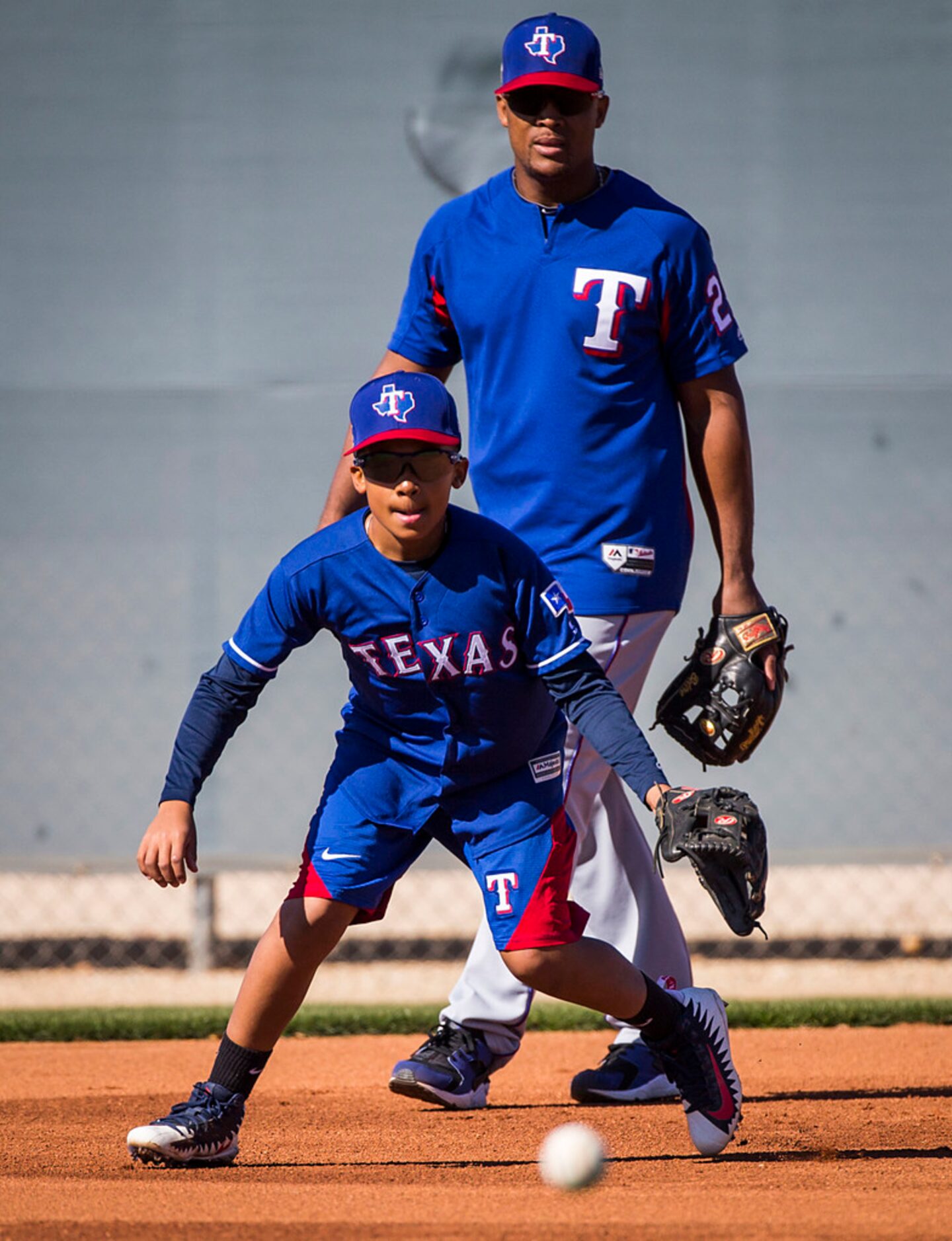 Adrian (A.J.) Beltre, Jr. takes grounders with his father, Texas Rangers third baseman...