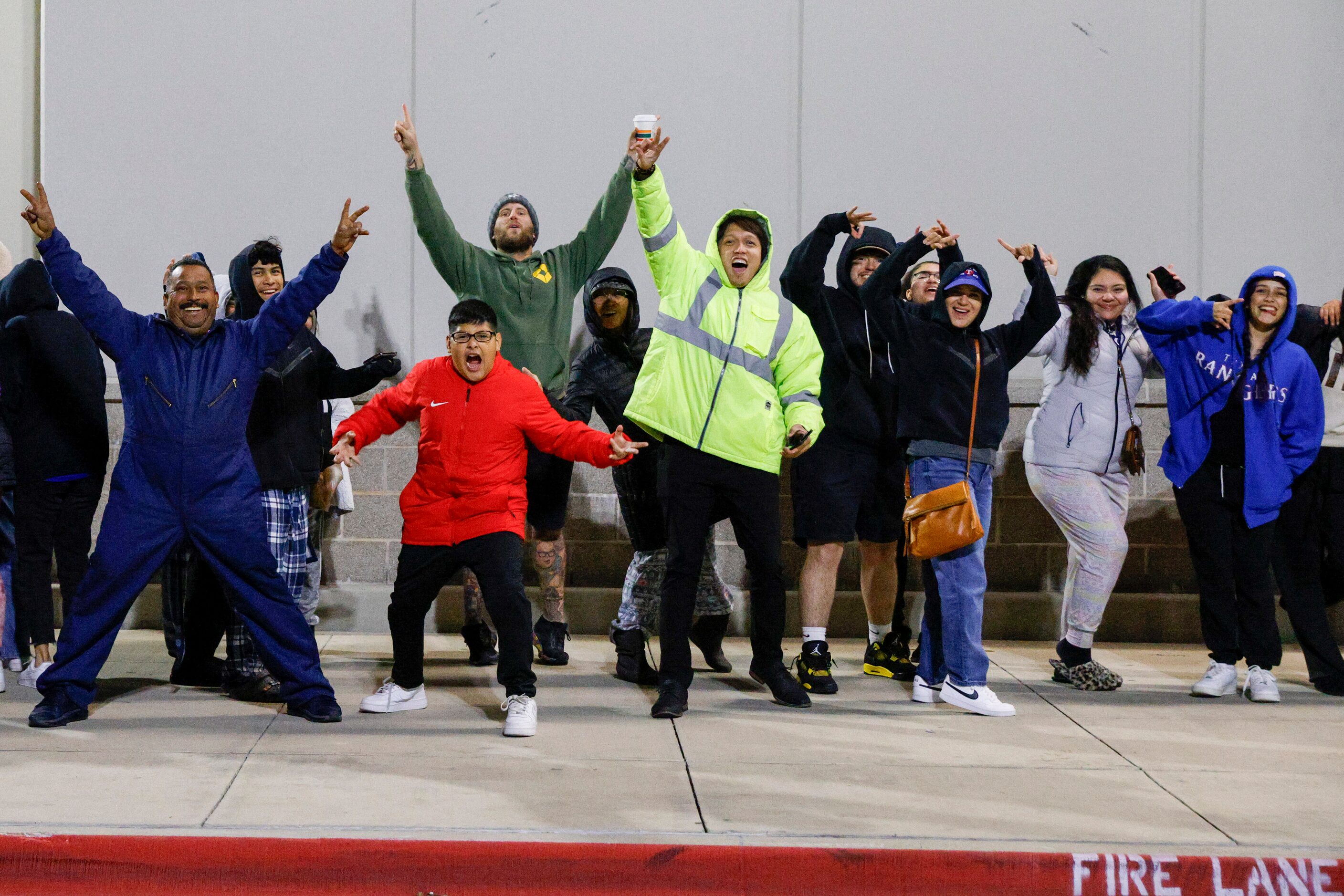 People cheer outside of an Academy Sports on Northwest Highway as they wait to buy Texas...