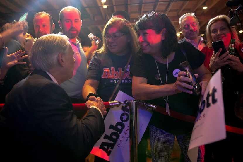 Texas Gov. Greg Abbott shakes hands with Lisa Vasquez during the Texas GOP election night...