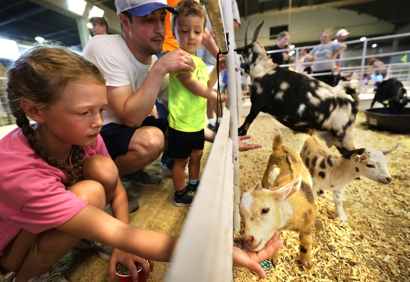 9-year-old Hadlie Bourg (left) fed a baby goat at the State Fair of Texas on Monday.