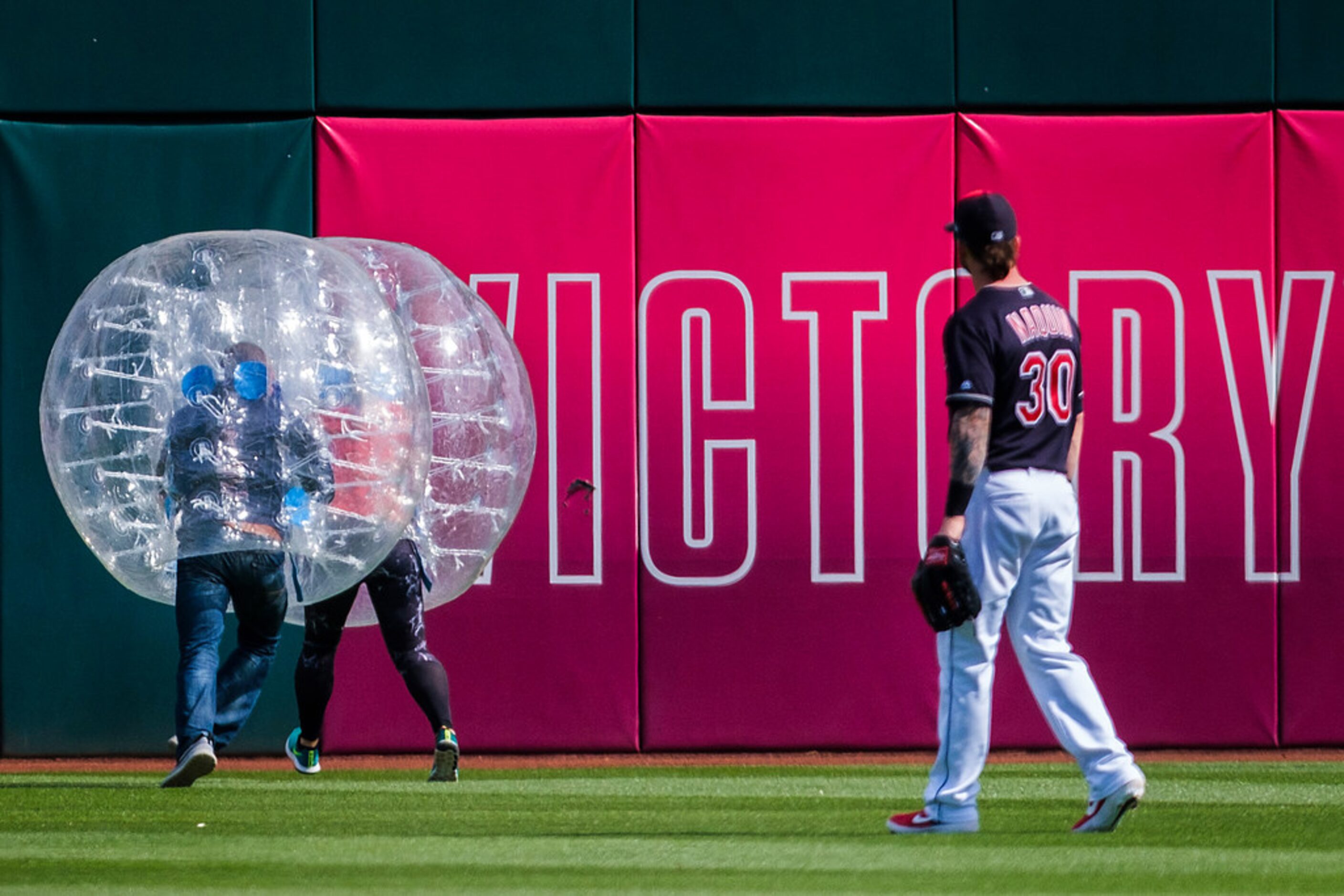 Cleveland Indians right fielder Tyler Naquin watches as fans compete in a promotional...