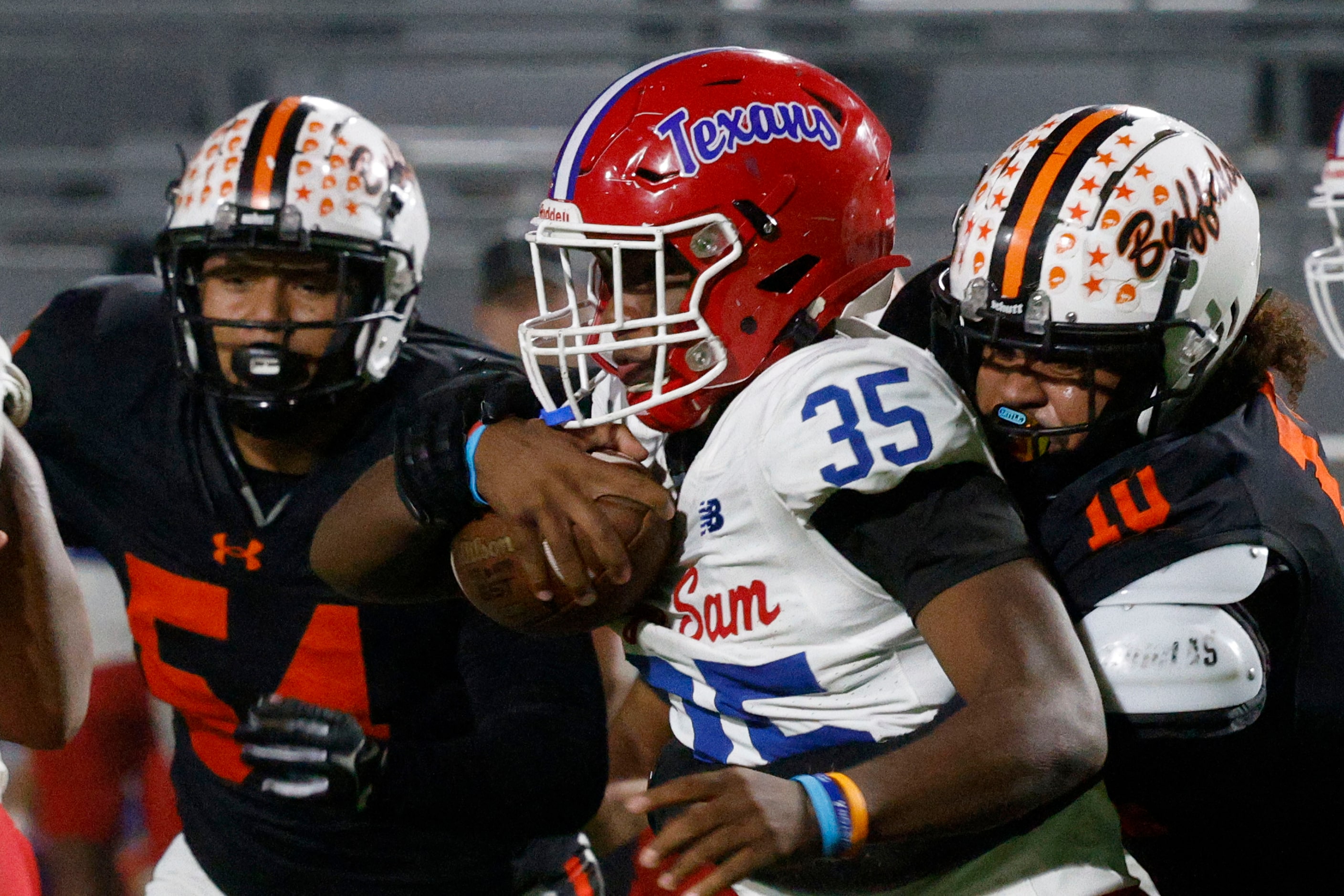 Sam Houston's Jokory Melbourne (35) is tackled by Haltom's Jayden Davis (10) as Haltom's...