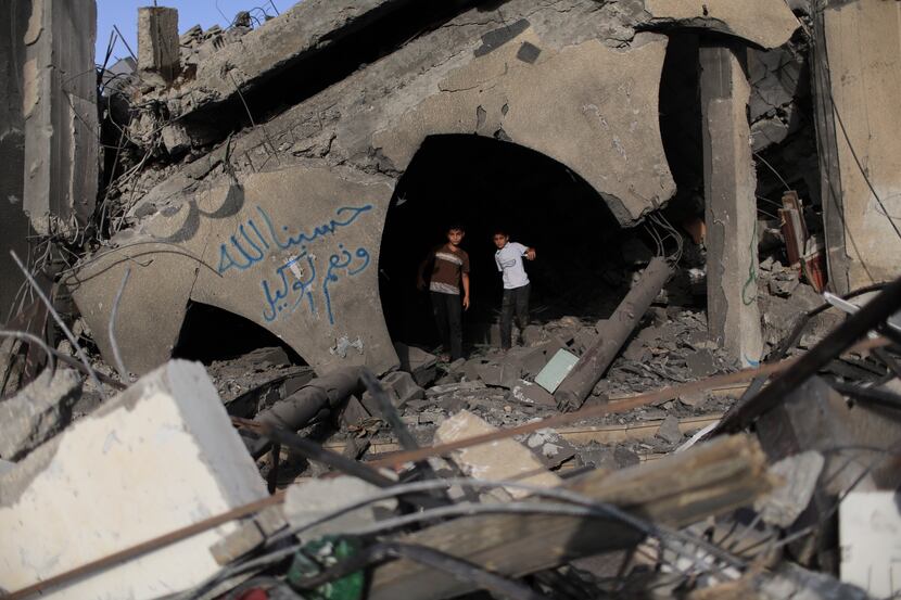 Palestinian children explore rubble at the site of a mosque destroyed by an Israeli...