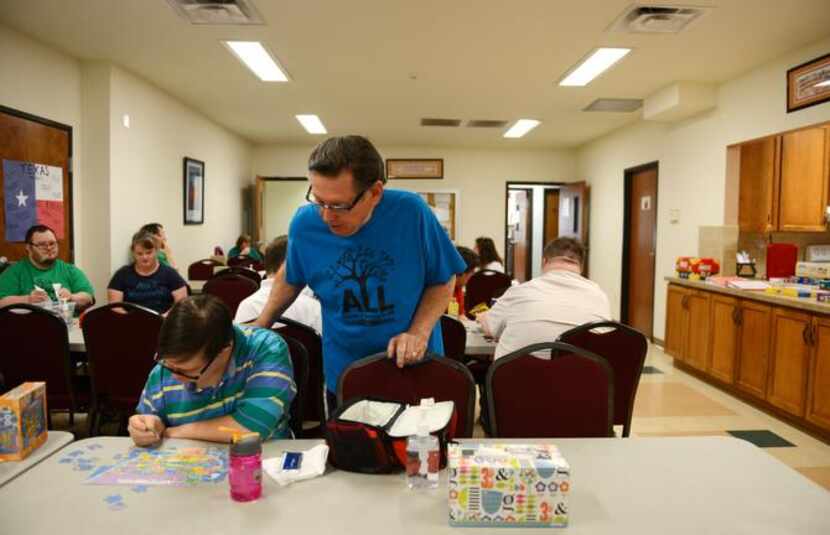 
Tom Horn watches as student Dana Parker works on a puzzle at the school.

