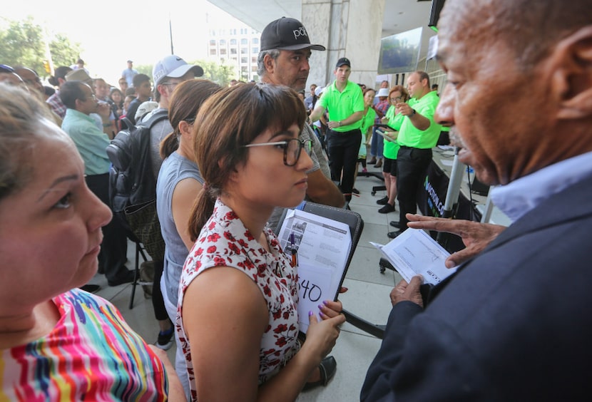 Ariana Paz (center), a new developer, talked with community activist Anthony Bond (right)...